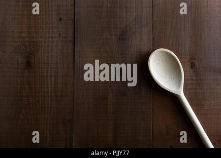 Traditional wooden spoon on a  dark board background. Stock Photo