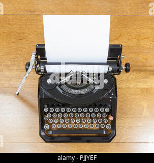 Vintage black typewriter on old oak table. Stock Photo