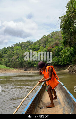 Chagres National Park, Panama - April 22, 2018: Native Embera man steering a dugout canoe along the river Stock Photo
