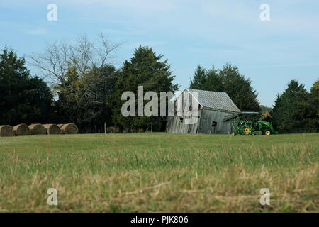 Hay bales and hay rake machine on field in Virginia's countryside