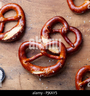 Freshly baked salted pretzel on wooden background. Beer snack. Top view Stock Photo