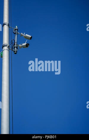 two surveillance cameras on a metal pole low angle view Stock Photo