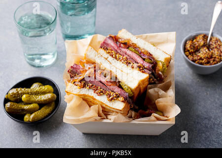 Sandwich with roast beef in wooden box. Grey stone background. Close up Stock Photo