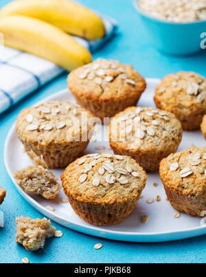 Healthy vegan oat muffins, apple and banana cakes on a white plate. Blue stone background Stock Photo