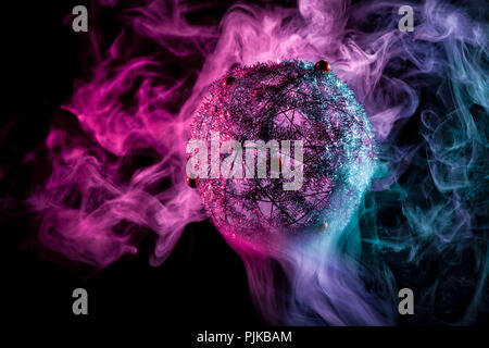 Silver shiny decoration Christmas balls in colored purple-red smoke, on an isolated black background. Concept of a modern Christmas card. Disco-ball i Stock Photo
