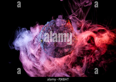 Close up  of a silver shiny decoration Christmas balls in colored purple-red smoke, on an isolated black background. Concept of a modern Christmas car Stock Photo