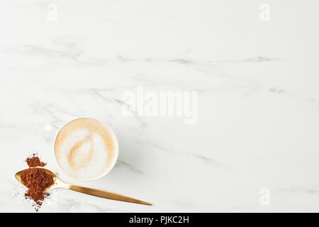Concept of coffee background. Flat lay of coffee and golden spoon with ground coffee on marble background. Top view with copy space. Stock Photo