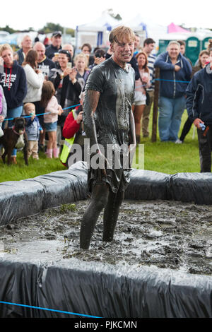 Man standing covered in mud at a mud wrestling contest at The Lowland Games, Thorney, Somerset, England Stock Photo