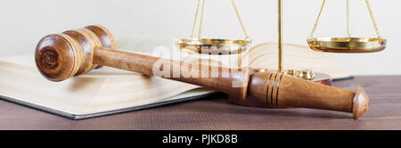 Symbols of law: wood gavel, soundblock, scales and opened volumetric old books Stock Photo