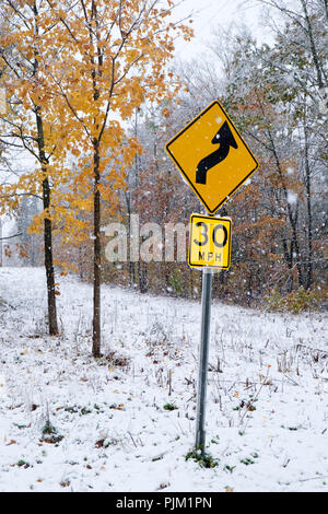 Early snowfall in autumn and a street sign for 30 mph on a country road in the Catskills in Upstate New York. Stock Photo