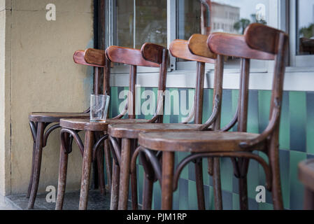 Impressions from the streets of Barcelona, ??4 wooden chairs in front of a street cafe with an empty glass Stock Photo