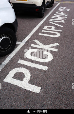 Pick up - drop off wording written on a road surface in the car park in Doncaster Stock Photo