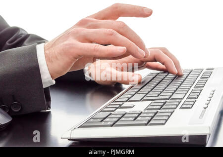 Closeup of male hands typing on keyboard on a black table. Stock Photo