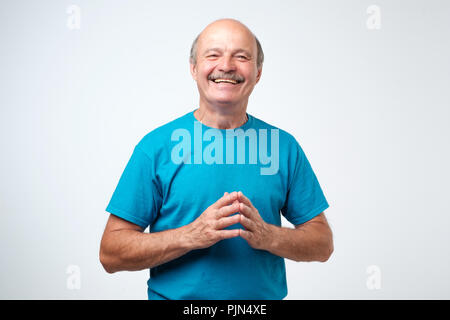 Portrait of a handsome senior man in blue t-shirt laughing Stock Photo