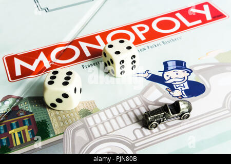 Monopoly Board Game close up with the box, board and dices. The classic real estate trading game from Parker Brothers Stock Photo