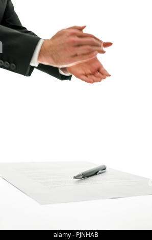 Businessman clapping his hands applauding a colleague, at an event or speech or for a successful business venture with a pen and paperwork below, isol Stock Photo