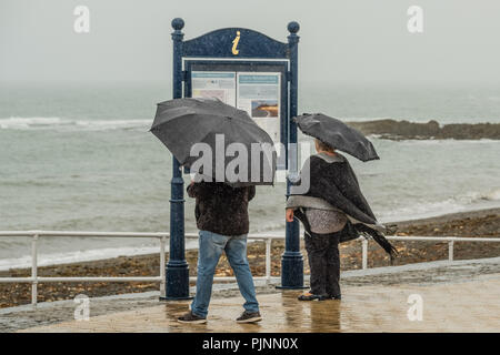 Aberystwyth Wales UK, Saturday 08 September 2018  UK Weather: People walking  under their umbrellas and wrapped up against the elements on a grey wet and dismal morning at the seaside in Aberystwyth, on the Cardigan Bay coast of West Wales   Photo © Keith Morris / Alamy Live News Stock Photo