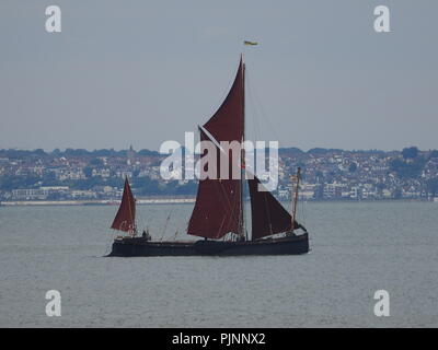 Sheerness, Kent, UK. 8th Sep, 2018. UK Weather: an overcast day  in Sheerness, Kent. A Thames barge sails past competitors taking part in short practice races ahead of tomorrow's 60th Round the Isle Of Sheppey Race. The race is organised by the Isle Of Sheppey Sailing Club and is open to sailing dinghies, catamarans and sailboards. Around 100 craft are expected to take part in the 40-mile clockwise circumnavigation of the island. Credit: James Bell/Alamy Live News Stock Photo