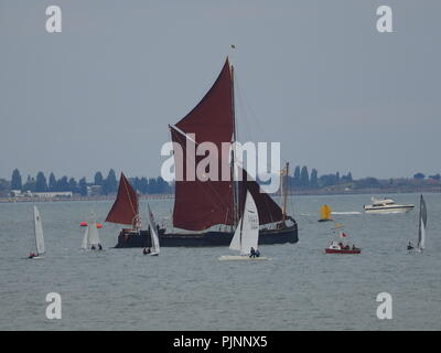 Sheerness, Kent, UK. 8th Sep, 2018. UK Weather: an overcast day  in Sheerness, Kent. A Thames barge sails past competitors taking part in short practice races ahead of tomorrow's 60th Round the Isle Of Sheppey Race. The race is organised by the Isle Of Sheppey Sailing Club and is open to sailing dinghies, catamarans and sailboards. Around 100 craft are expected to take part in the 40-mile clockwise circumnavigation of the island. Credit: James Bell/Alamy Live News Stock Photo