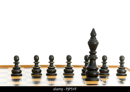Old chess figures. Black king with line of pawns behind him. Isolated over white background. Stock Photo