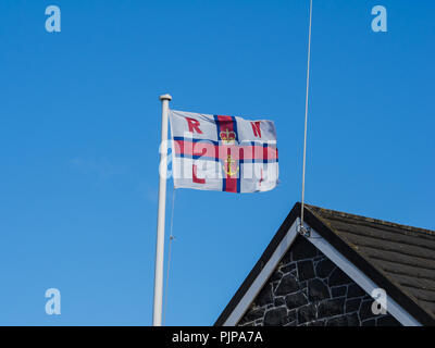 RNLI flag flying in the breeze above Donaghadee lifeboat station Stock Photo