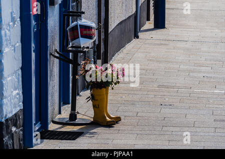Old RNLI wellingtons upcycled as flower planters outside the RNLI station in Donaghadee Stock Photo