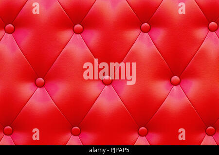 Elegant saturated glossy red leather texture of sofa chair. Stock Photo