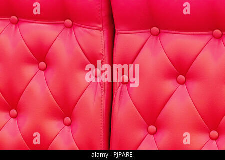 Elegant saturated glossy red leather texture of sofa chair. Stock Photo