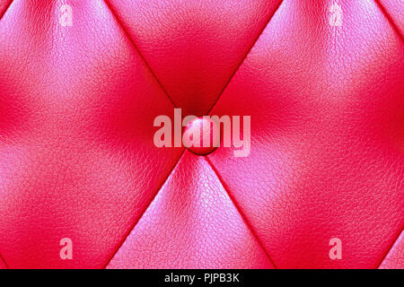 Elegant saturated glossy red leather texture of sofa chair. Stock Photo