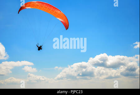 Paraglider floating in the air against the sky. Stock Photo