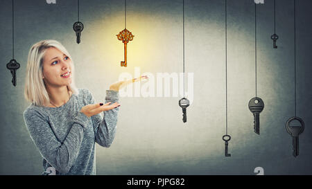 Young woman find the magic golden key. Concept of business aspirations, holding success in hands, achievement and the right choice. Stock Photo