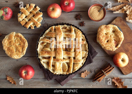 Homemade Apple Pies on rustic background, top view. Classic autumn Thanksgiving dessert - organic apple pie. Stock Photo