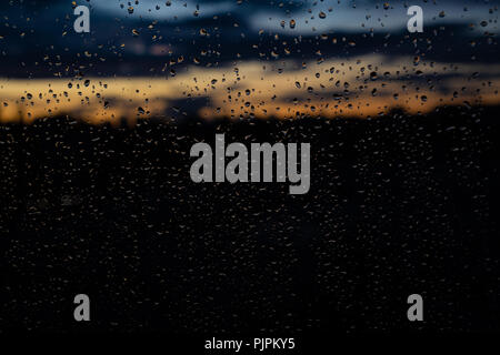 closeup of raindrops on window in the evening, beautiful sunset colours Stock Photo