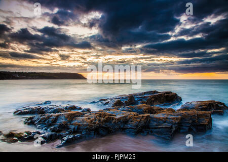 Sunset over the beach at Tresaith in Ceredigion, Wales, looking towards Aberporth. Stock Photo