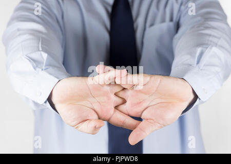 A business man cracking his knuckles, focusing on hand and finger joints, illustrating themes of stress relief, joint care, and medical concept Stock Photo