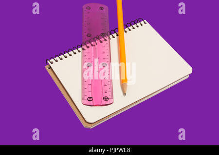 spiral opened notebook with pencil and ruler lying on a purple background. concept of office stationary. free copyspace Stock Photo