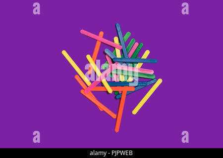 bunch of multicolored plastic counting sticks for children lying on a purple background. concept of mathematical operations. free space for advertisin Stock Photo
