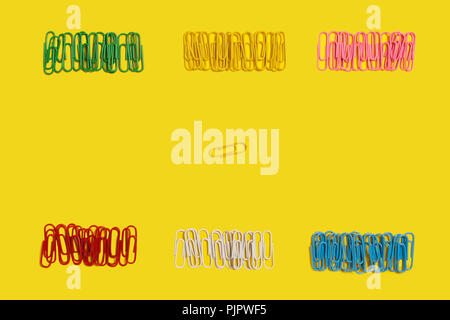 diversity of different in colours paper clips lying on a yellow background. free space for advertising text. concept of office chancery Stock Photo