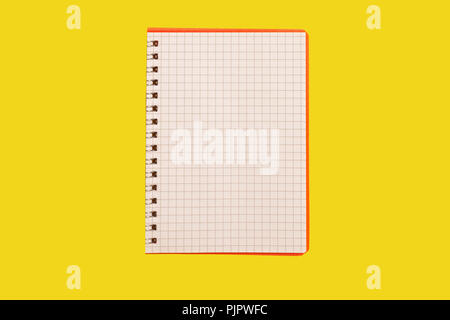 opened spiral notebook lying on a yellow surface. concept of office stationary. free copyspace Stock Photo
