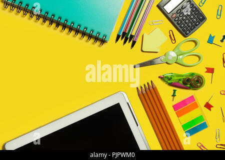 various school and office suplies and gadgets lying on a yellow background. free space for text Stock Photo