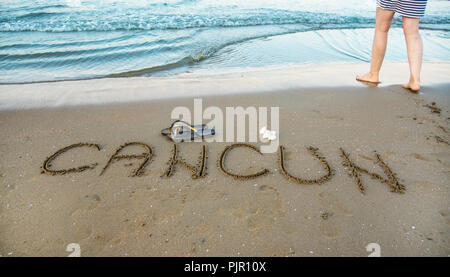 The word Cancun written in the sand on beach. Vacation concept Stock Photo