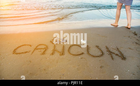 The word Cancun written in the sand on beach. Vacation concept Stock Photo