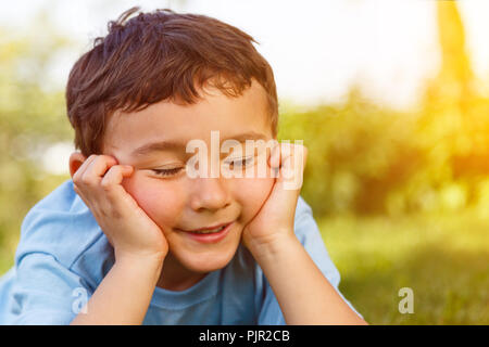 Child kid little boy day dreaming daydreaming thinking outdoor copyspace copy space outdoors outside nature Stock Photo