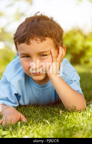 Child kid little boy thinking think looking outdoor portrait format vertical Stock Photo