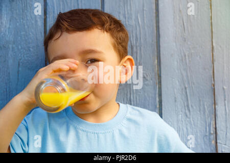 Child kid little boy drinking orange juice drink outdoor copyspace copy space outdoors outside glass Stock Photo