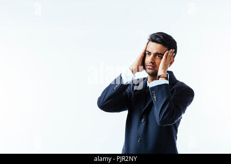 Portrait of a cool businessman holding his head in disbelief or in pain, isolated on white background Stock Photo