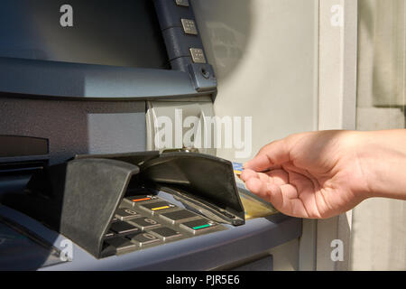 Close-up view of cash machine and woman's hand with credit card Stock Photo