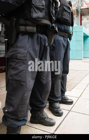 Two armed PSNI police officers stand on the street in uniform, Belfast, Northern Ireland. Stock Photo