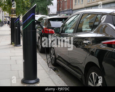 Electric cars charging at a charging point on a London street Stock Photo