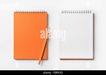 Design concept - Top view of orange spiral notebook and color pencil collection isolated on white background for mockup Stock Photo
